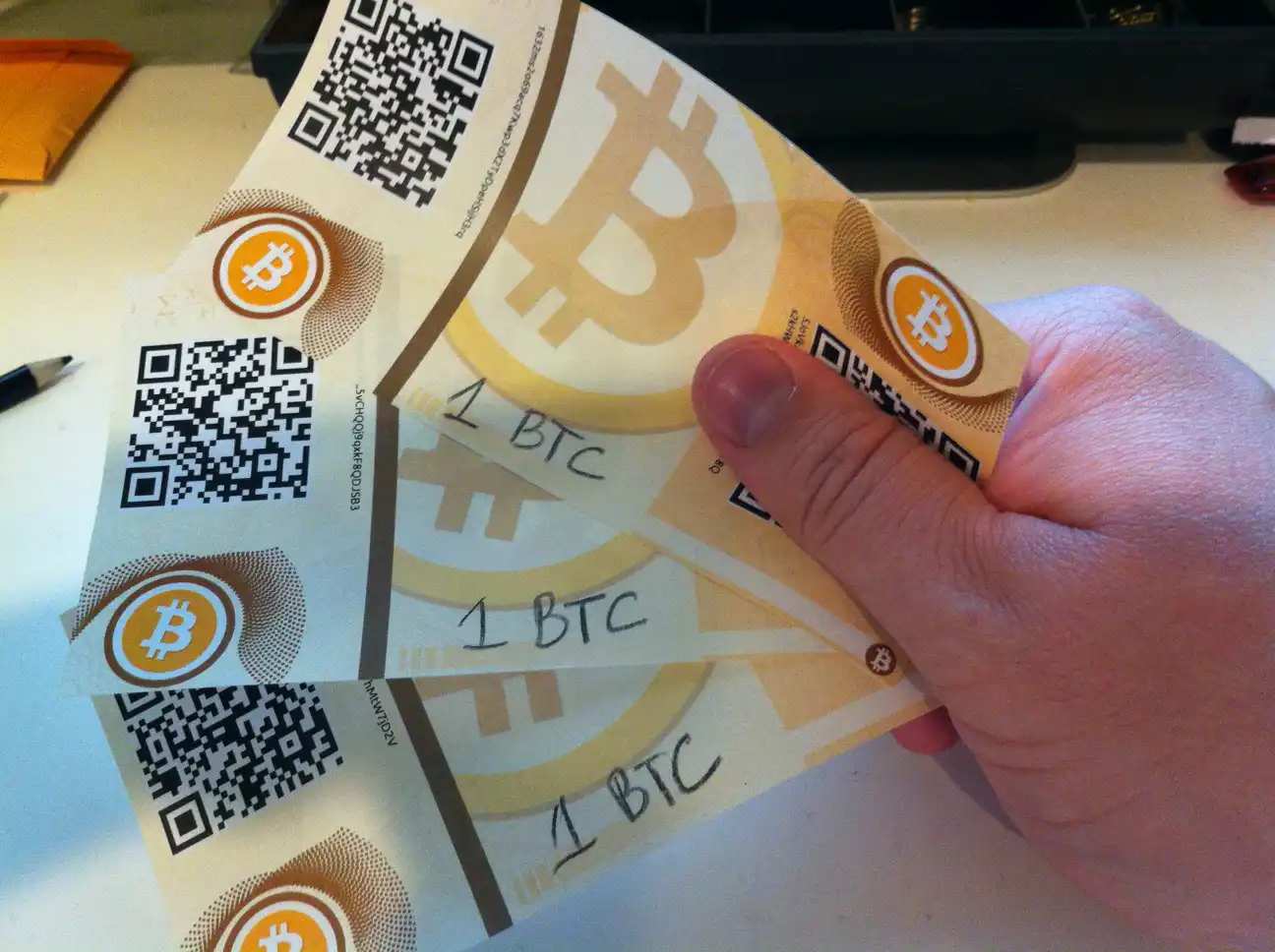 Casascius (an OG bitcoiner) holding 3 early paper wallets of 1 BTC each
